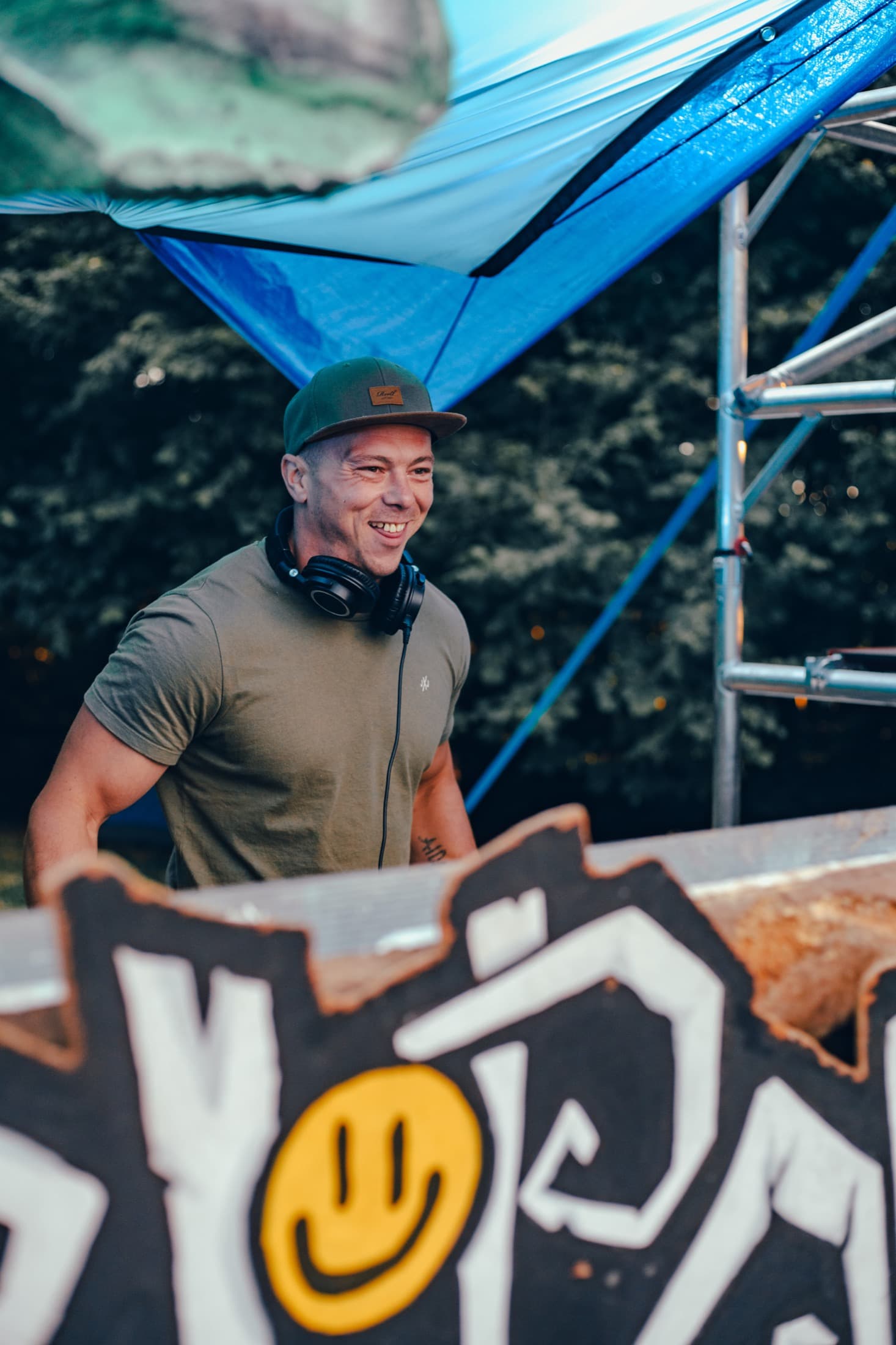 Smiling DJ behind the decks at a festival