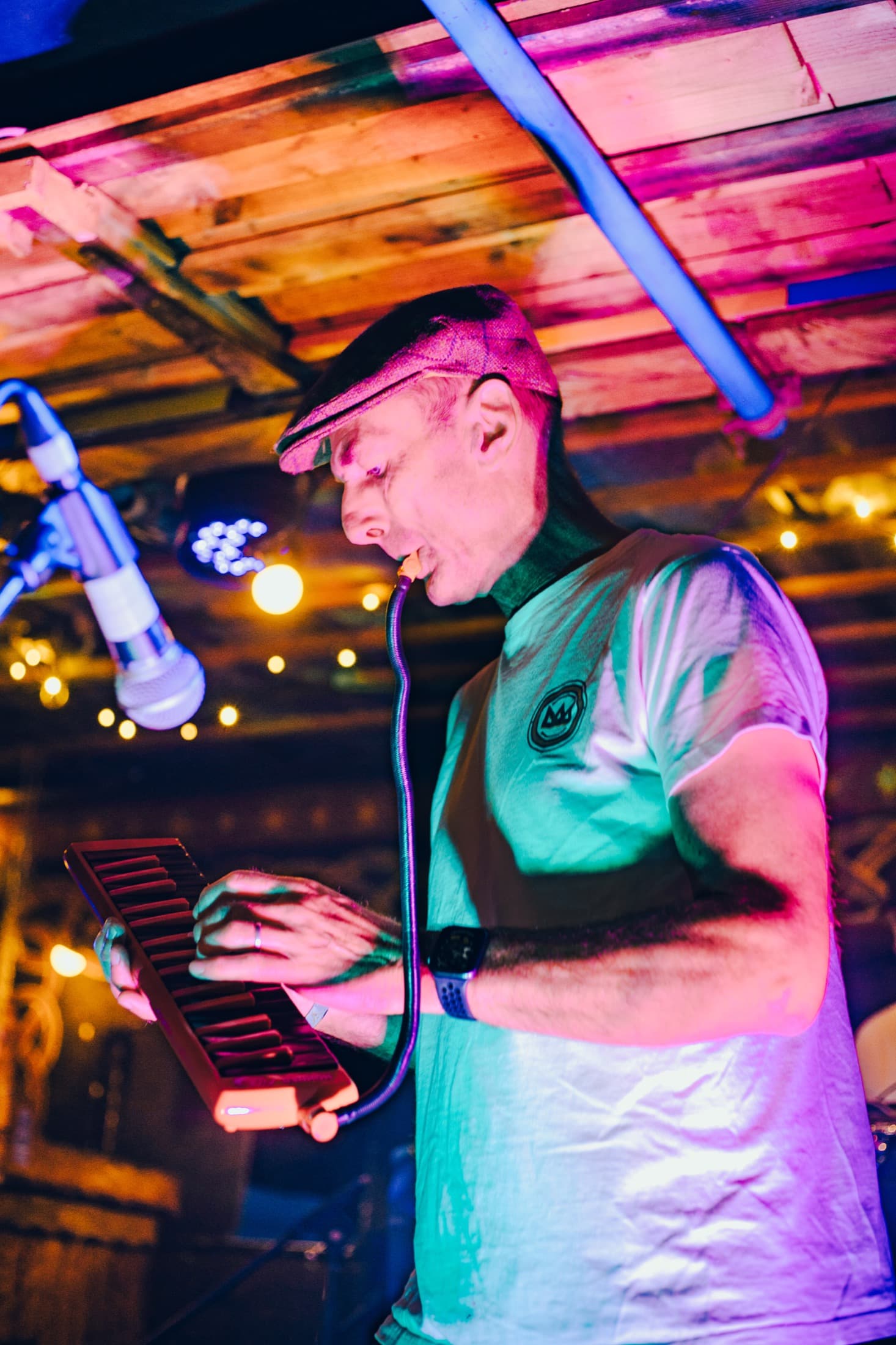 Musician playing melodica under colourful lights