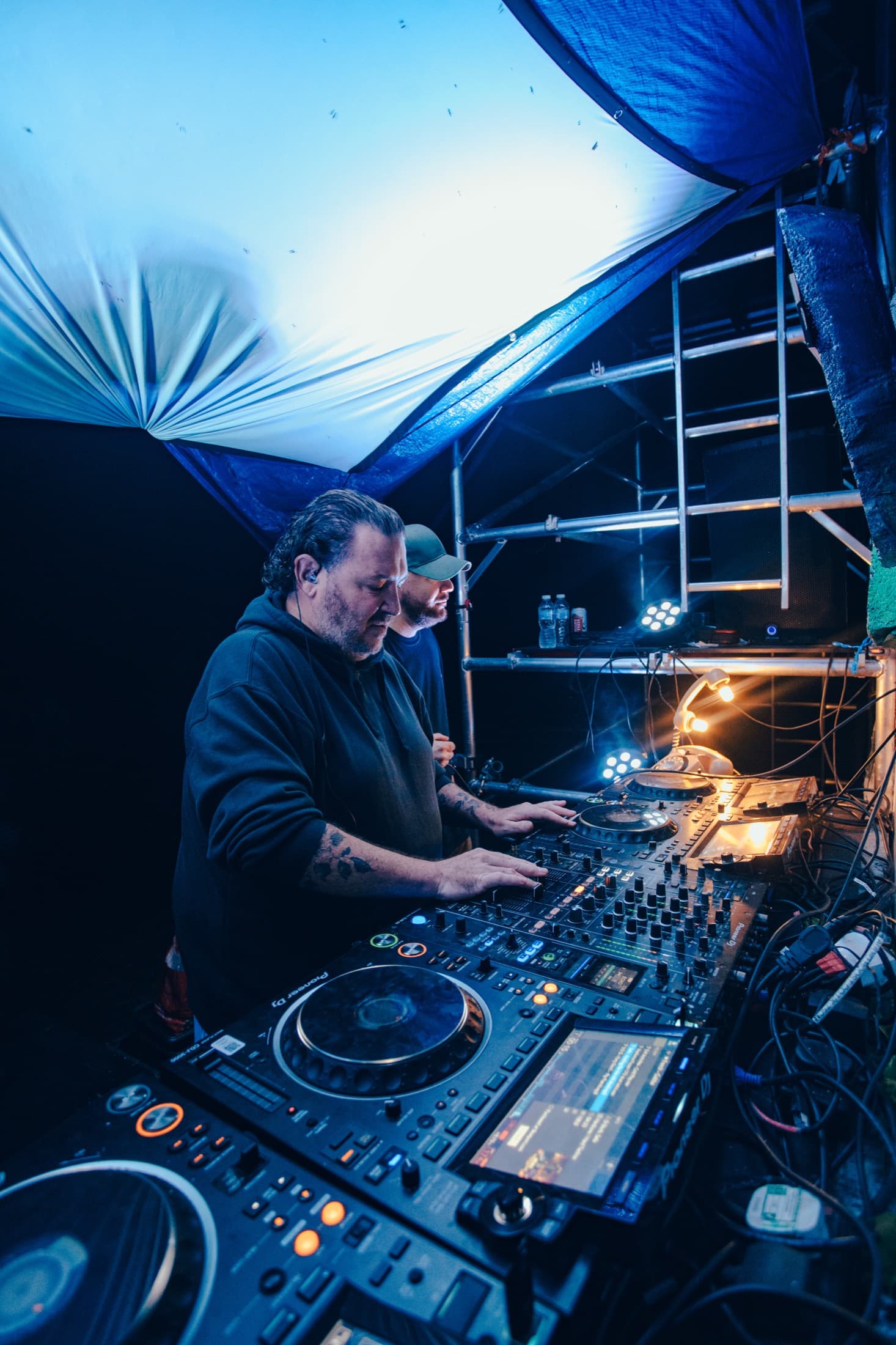 DJs performing at night behind festival decks
