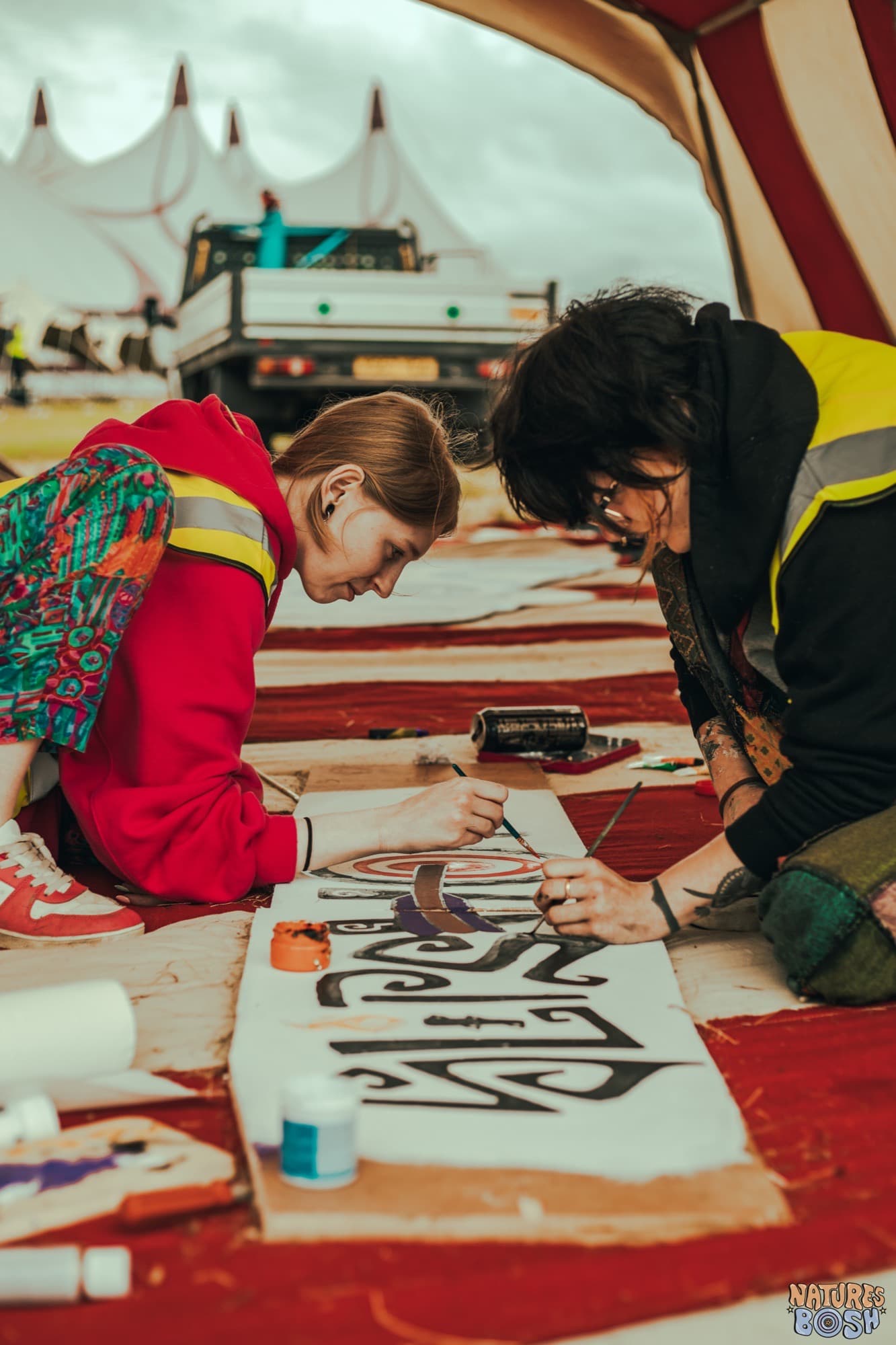 Crew hand-painting festival signage during build week